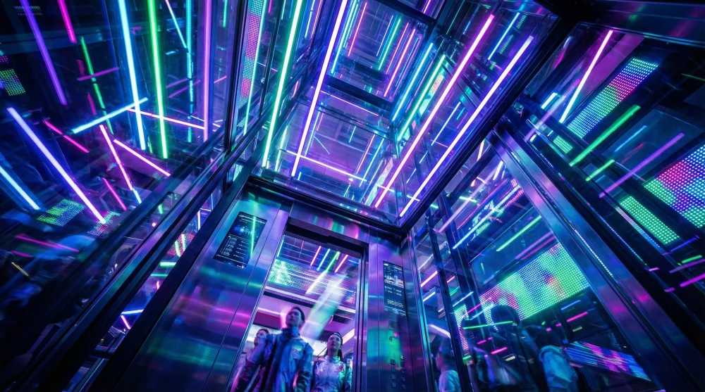 Futuristic elevator interior at A'DAM Lookout featuring a neon light show and glass ceiling