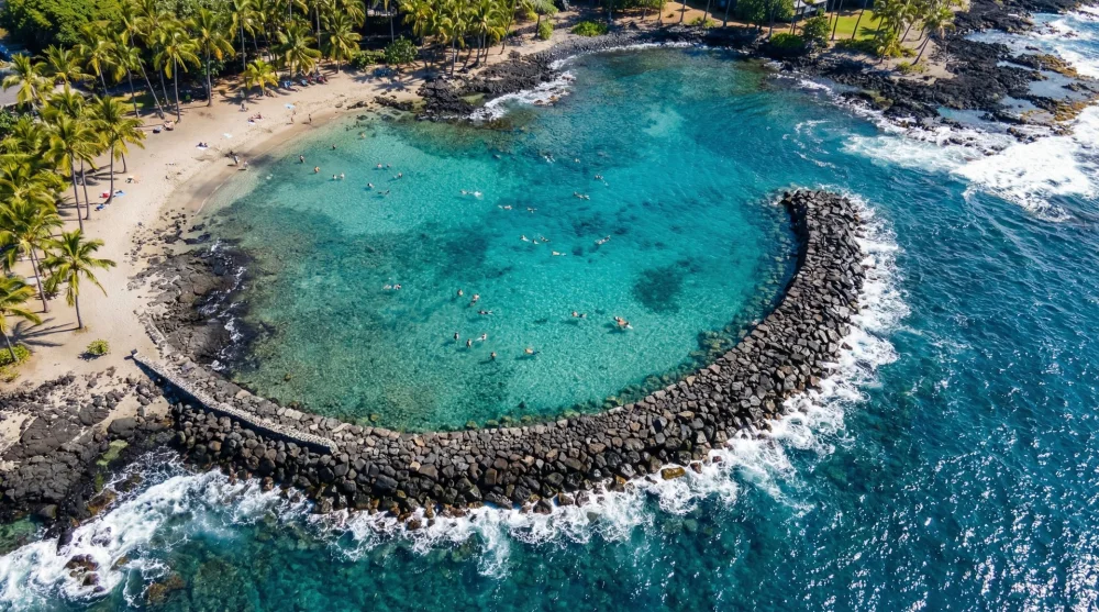 Aerial view of Kahaluu Bay showing the breakwater protecting the calm snorkeling area from ocean swells