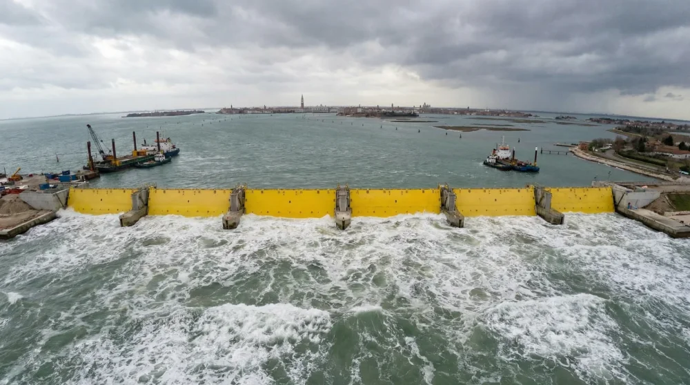 The yellow steel gates of the MOSE flood barrier system rising to protect the Venetian lagoon