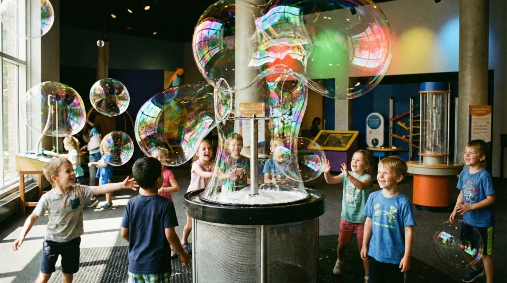 Kids playing with giant soap bubbles at the Fenomena floor in NEMO Science Museum