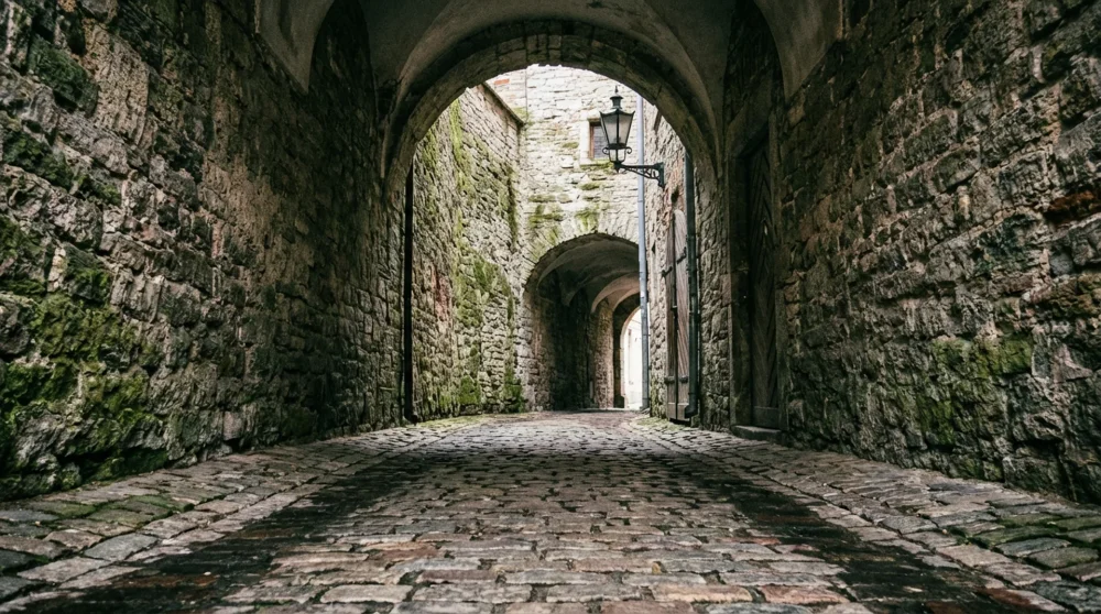 Inside the tunnel of the Swedish Gate in Riga highlighting the thick medieval stone walls and worn cobblestones