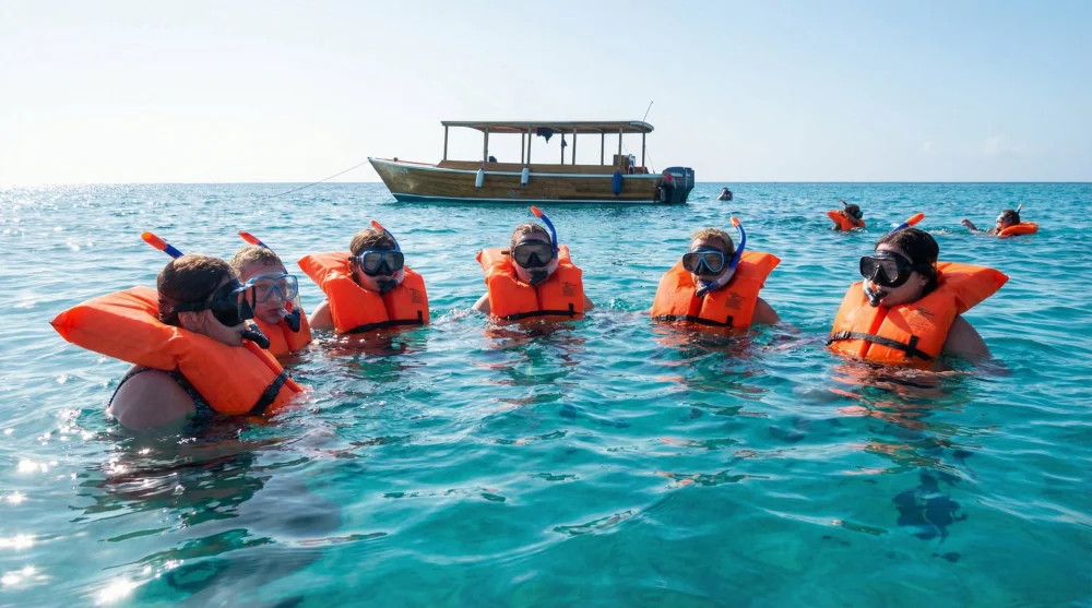 Group of tourists snorkeling wearing mandatory orange life vests in Cancun Marine Park
