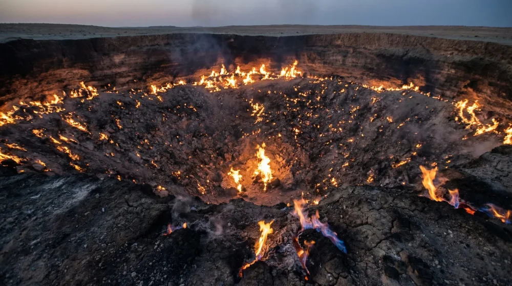 Detailed view of natural gas flames flickering inside the scorched earth of Darvaza Crater