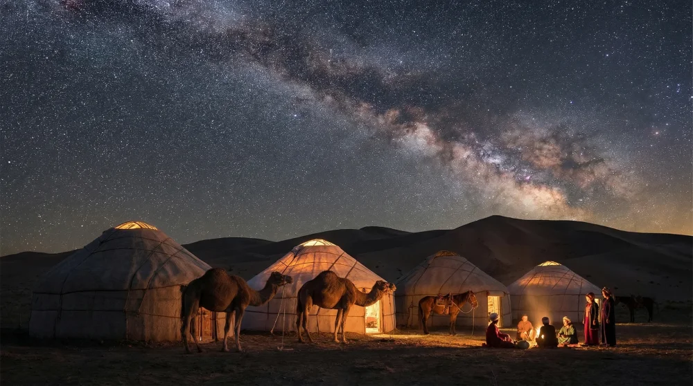 Traditional Turkmen yurt camp illuminated at night under a starry sky in the Karakum Desert