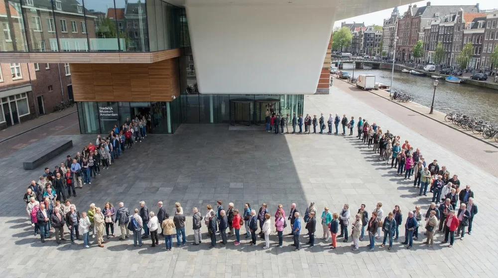 Tourists waiting at a museum entrance in Amsterdam emphasizing the time slot system