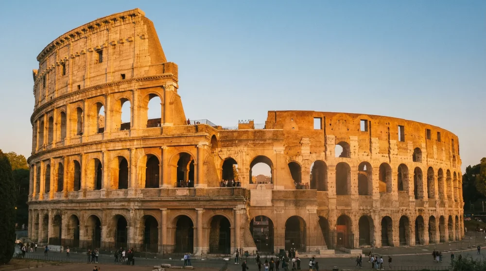 The ancient Roman Colosseum illuminated by warm golden hour sunlight in Italy