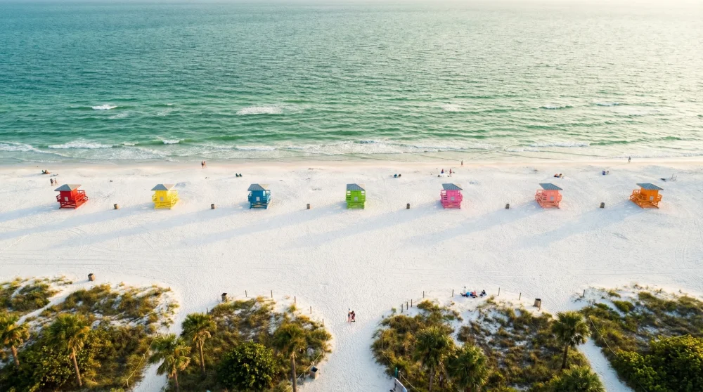 Aerial view of the wide white sand shoreline and turquoise Gulf waters of Siesta Key Beach.