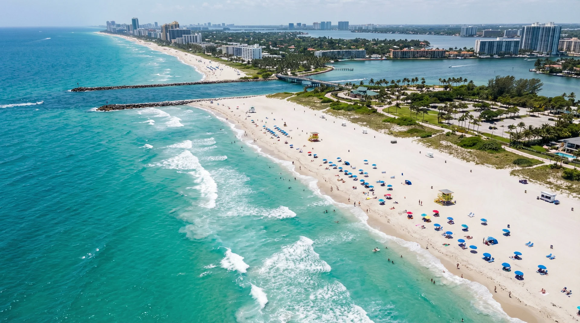 Wide aerial perspective of Haulover Beach with clear turquoise water and white sandy shoreline