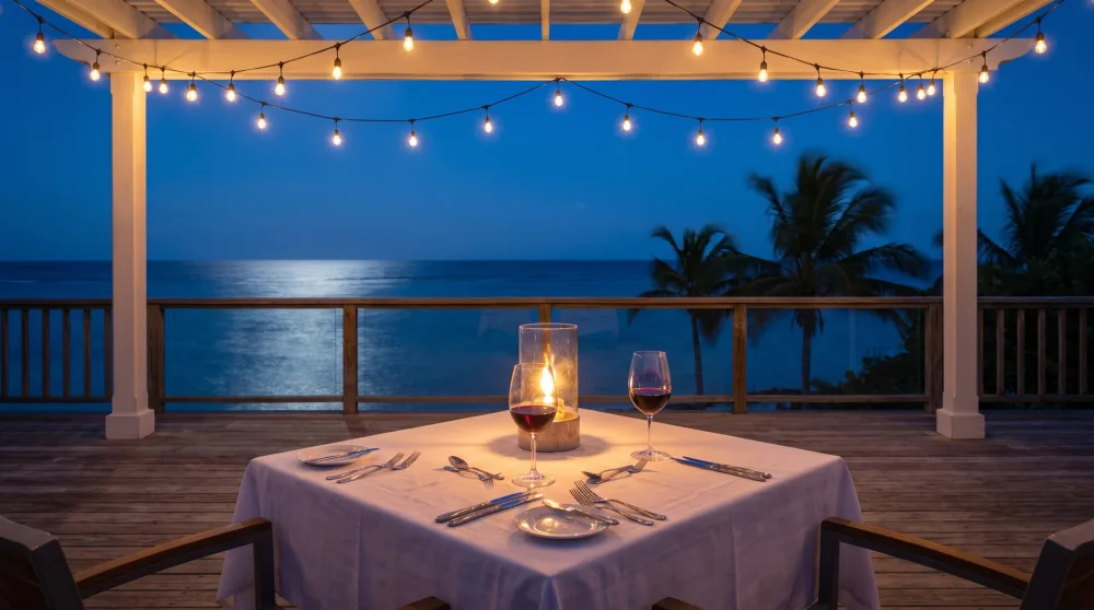 Romantisch gedeckter Tisch für zwei mit Blick auf das Karibische Meer bei Nacht