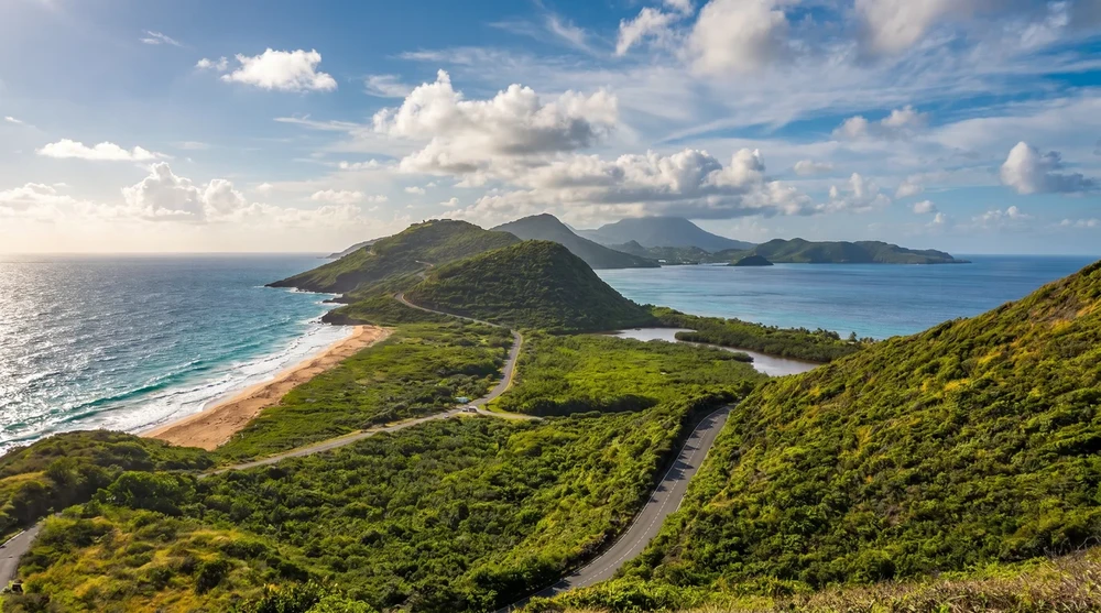 Südöstliche Halbinsel von St. Kitts vom Aussichtspunkt Timothy Hill aus fotografiert, links bricht die atlantische Brandung, rechts die ruhige karibische Cockleshell Bay, dahinter erhebt sich der Nevis Peak über dem Kanal.