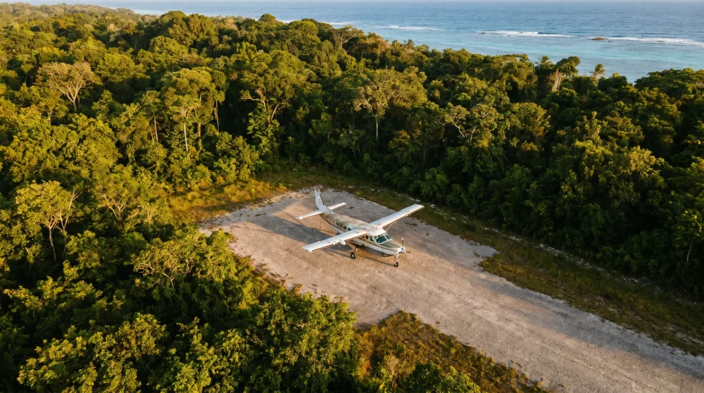 Ein kleines Turboprop-Flugzeug auf dem Vorfeld des Ian Fleming International Airport in Ocho Rios, umgeben von tropischem Dschungel