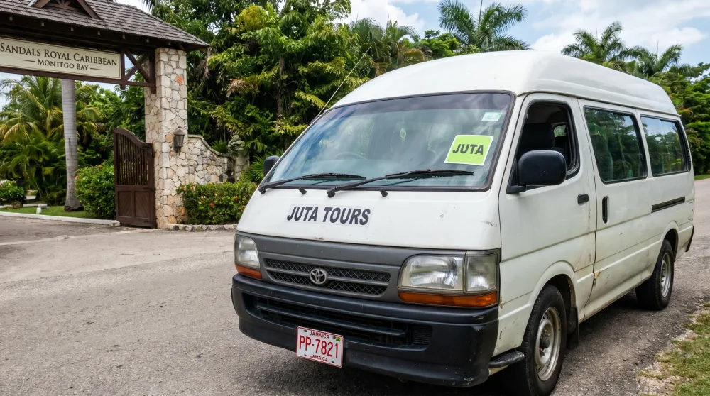 JUTA Jamaica taxi with red and white license plate and lime-green sticker parked outside resort entrance