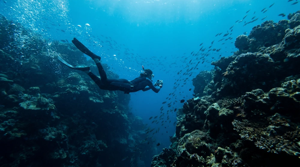 Drifting snorkeler in a strong current channel between reefs in the Maldives