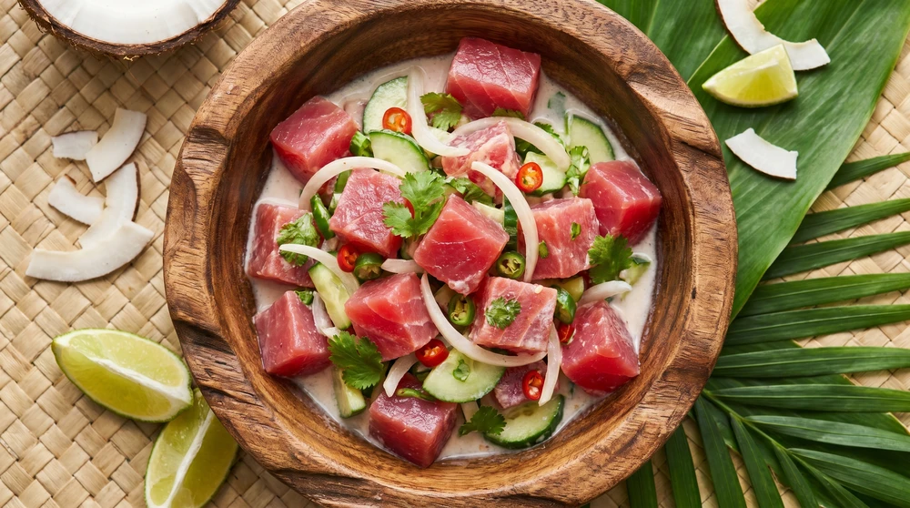 Frischer marshallesischer roher Fischsalat mit Kokosmilch und Limette in einer tropischen Schüssel, Poke-Stil mit frischem Thunfisch von oben fotografiert. Ein Signature-Gericht der marshallesischen Küche.