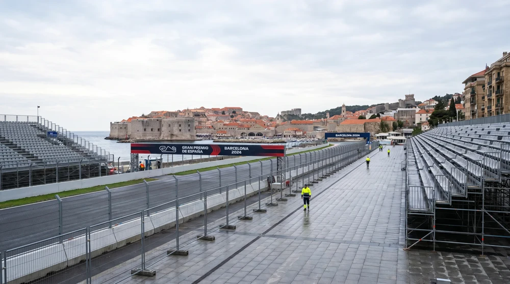 Pedestrian walking along the Monaco Formula 1 Grand Prix street circuit with empty grandstands