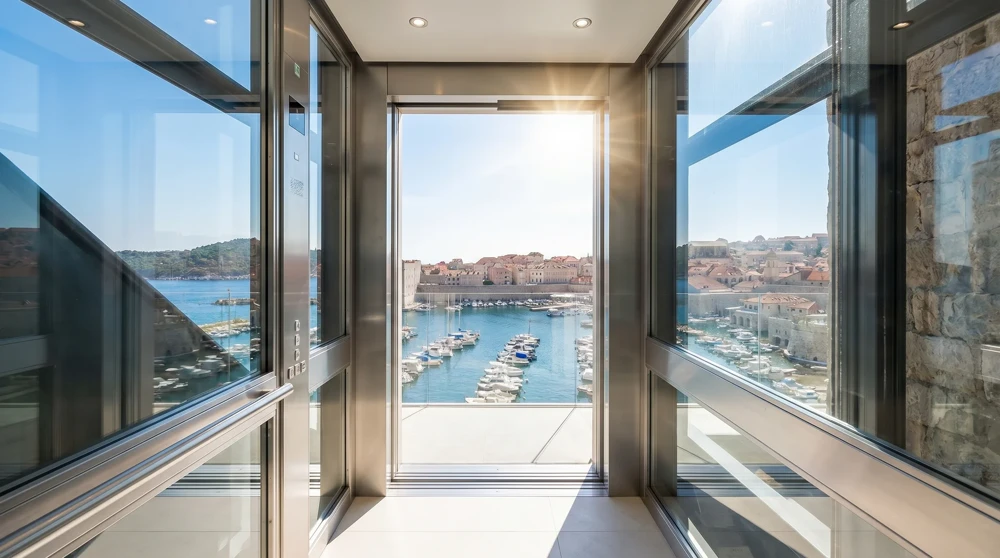 Public cliff elevator in Monaco opening to reveal a view of the Mediterranean harbor below