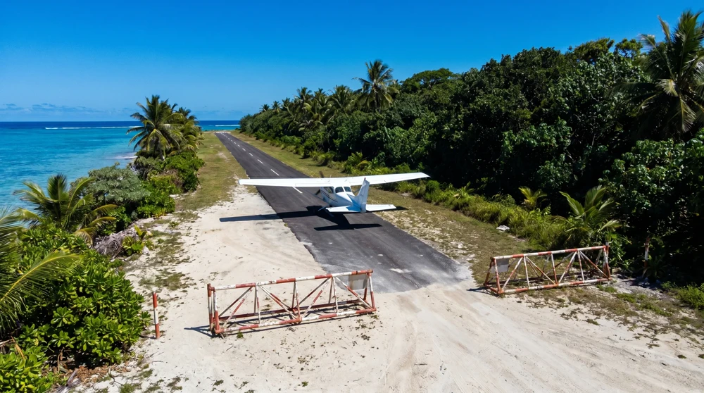 Nauru Airlines aircraft landing on the runway that crosses the island's main coastal road