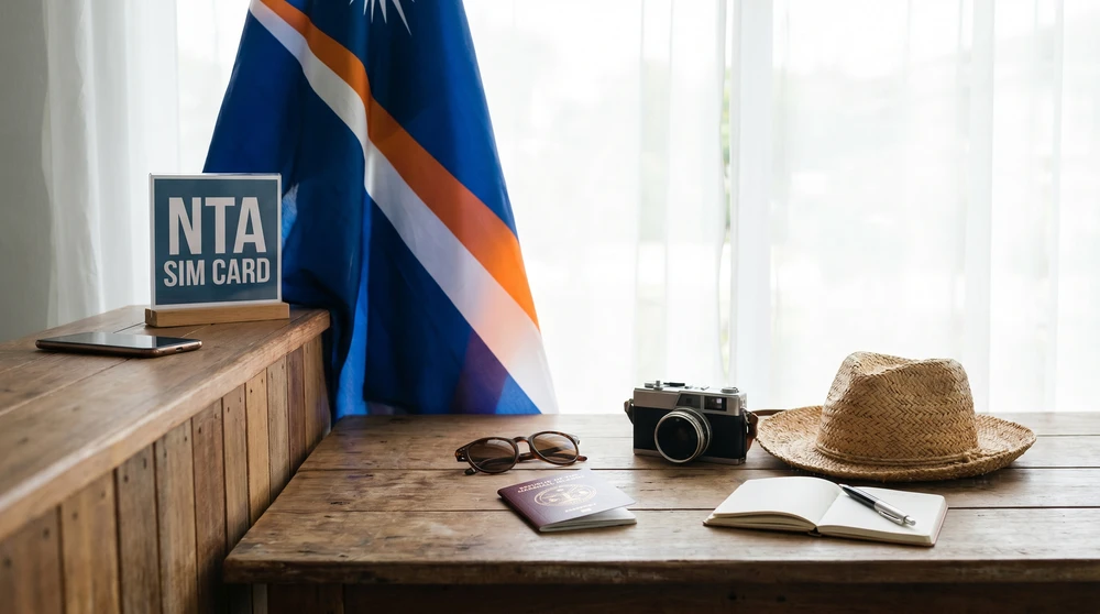 An NTA SIM card counter in the Marshall Islands with travel accessories and a mobile phone on a wooden surface. The National Telecommunications Authority is the only mobile operator in the country.