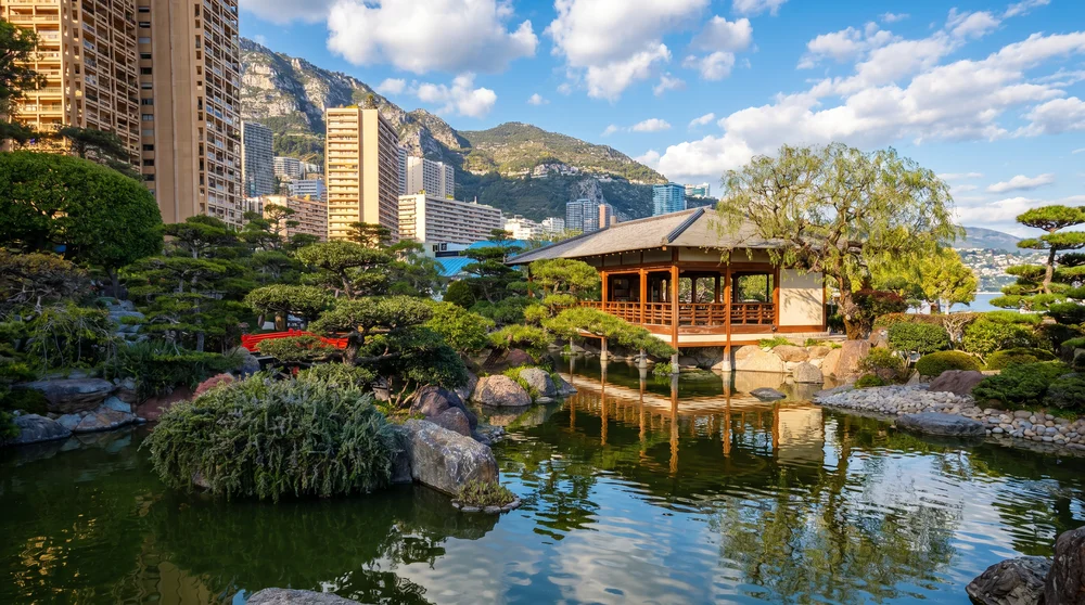 Japanese tea pavilion reflected in koi pond at Princess Grace Japanese Garden Monaco