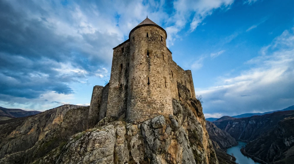 Guaita tower exterior on cliff edge in San Marino showing medieval stone fortification against blue sky