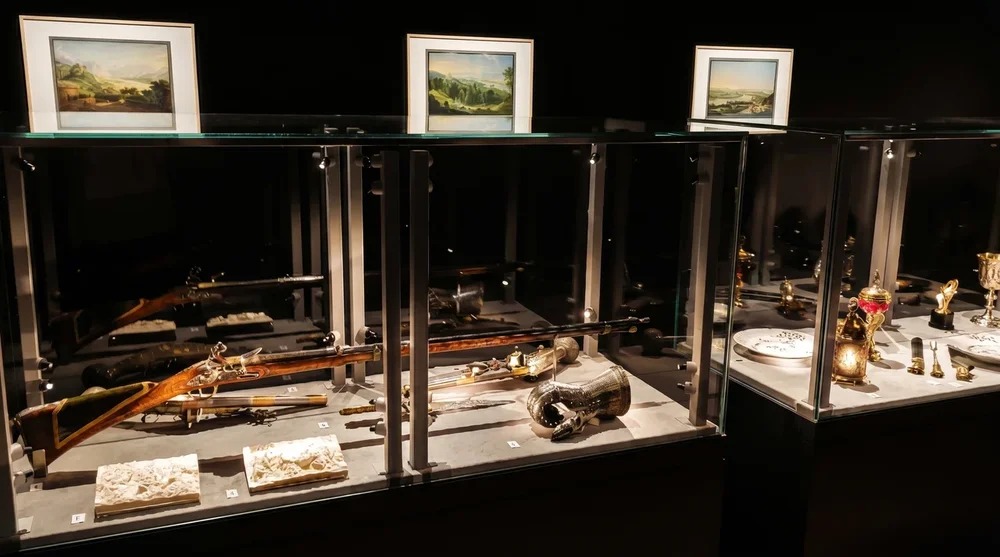 Glasvitrinen mit historischen Waffen Jagdgewehren und goldenen Zeremoniengegenstaenden in der Liechtensteinischen Schatzkammer