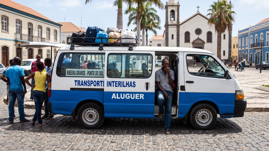 A shared aluguer minivan parked in a Cape Verde town square ready to take passengers between villages