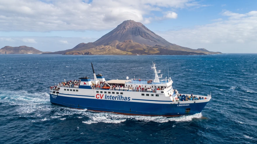 A CV Interilhas passenger ferry crossing between Cape Verde islands with a volcanic island visible in the background