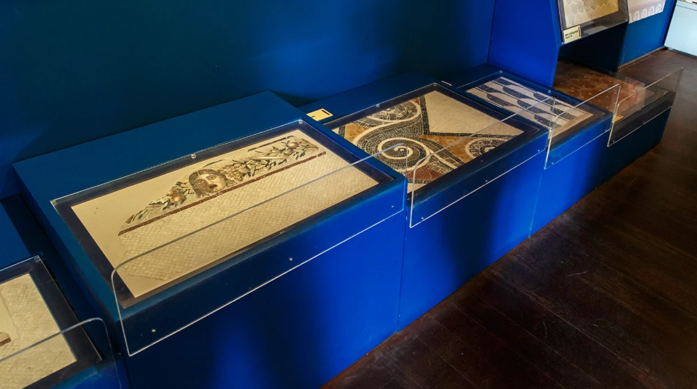 Display cases of fragmentary Roman mosaic panels at the Domus Romana museum in Rabat, Malta