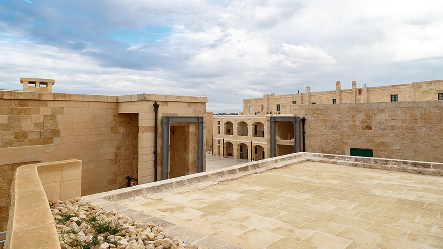The restored open terrace and inner courtyard of Fort St Elmo with honey-coloured limestone ramparts in Valletta
