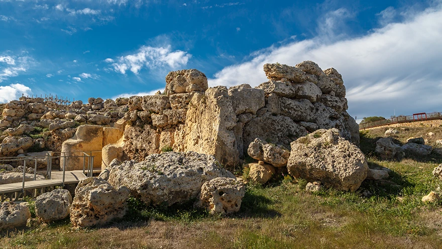 Panoramic view of the weathered Ggantija temple ruins under a dramatic Gozo sky in late afternoon light