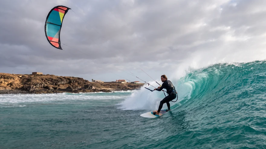 Advanced kitesurfer riding a right-hand wave at Ponta Preta, Sal Island, Cape Verde