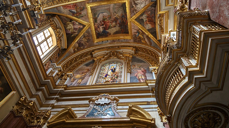 Vergoldete Barockdecke und Buntglasfenster über dem Altar im Inneren der Paulskathedrale in Mdina
