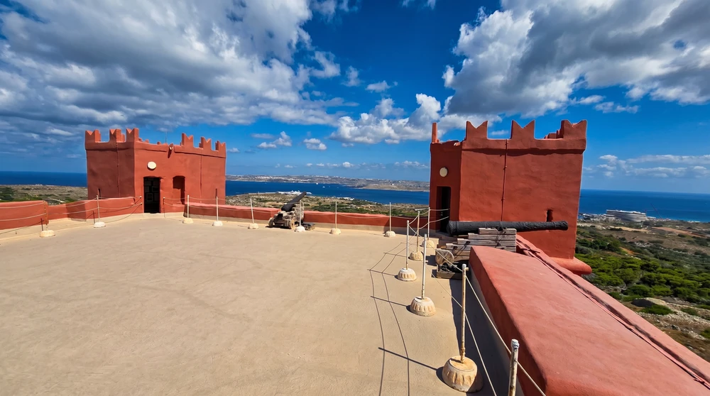 The rooftop terrace of St Agatha's Red Tower in Malta with its corner turrets, old cannons and sweeping sea views