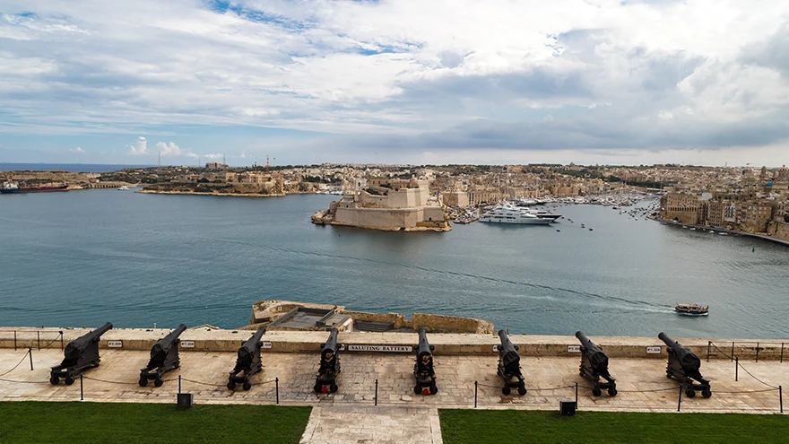 A row of cannons on the Saluting Battery terrace below Upper Barrakka Gardens overlooking the Grand Harbour and Fort St Angelo