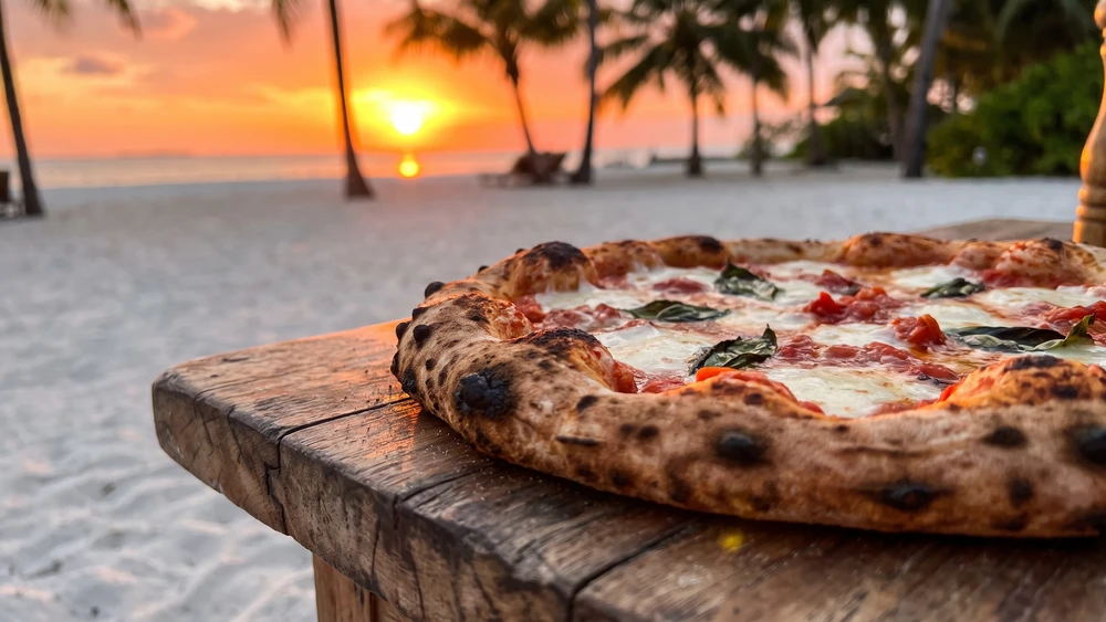 Stone-grilled pizza dinner on the beach at sunset