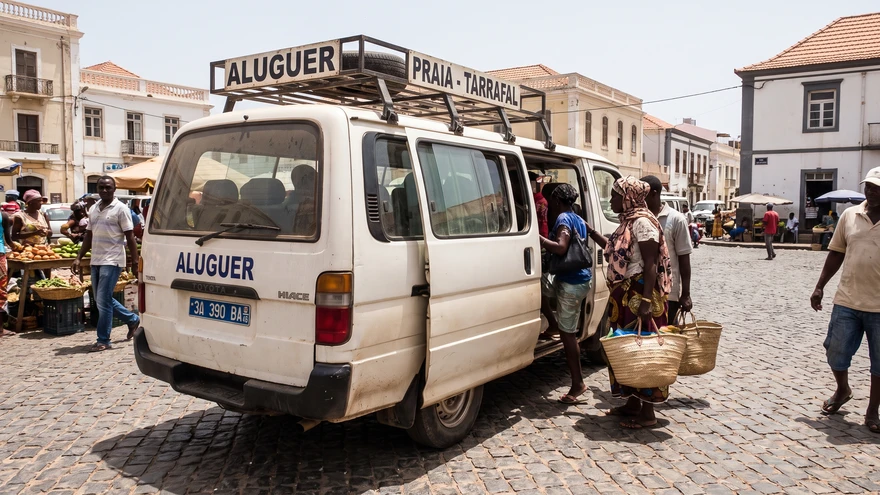 Passengers boarding a shared aluguer minibus at a town square in Cape Verde