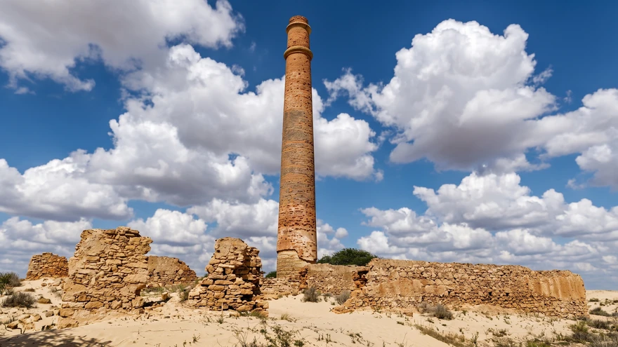 Brick chimney ruins of an 18th-century ceramics factory rising from sand dunes at Praia de Chaves, Boa Vista