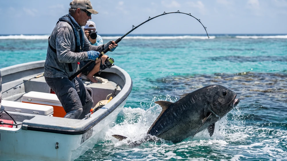 Angler battling a giant trevally near the reef edge