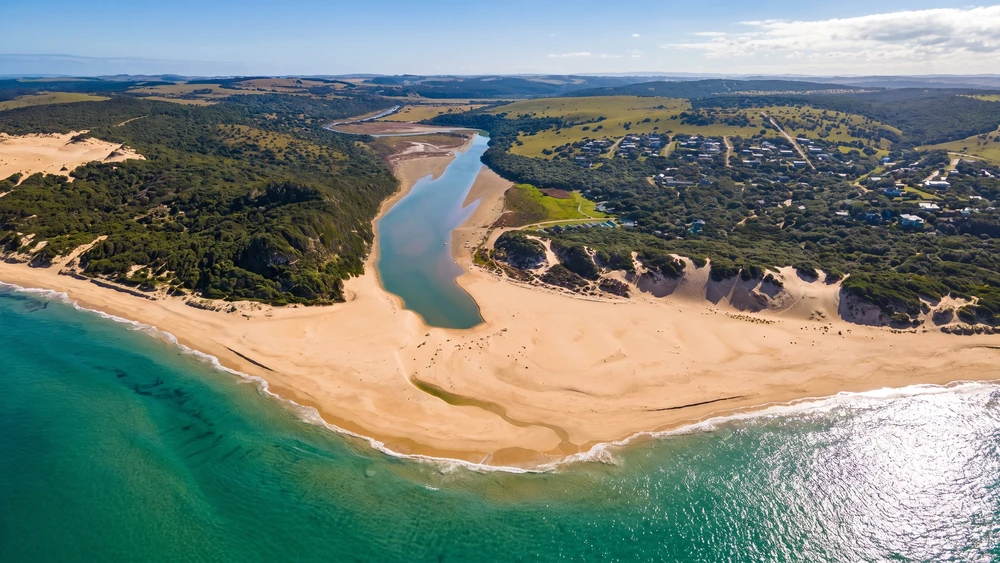 Aerial view of the Kasouga River estuary winding past Kasouga village toward the Indian Ocean