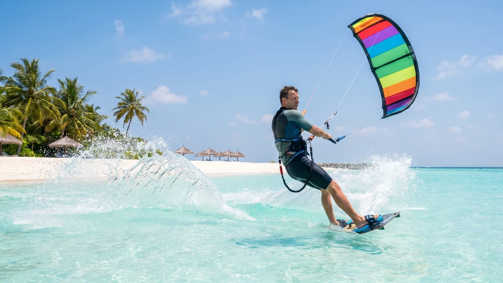 Kitesurfer riding across a shallow turquoise lagoon