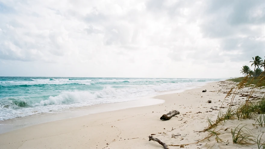 Wide Atlantic-facing beach with rolling turquoise waves and empty white sand