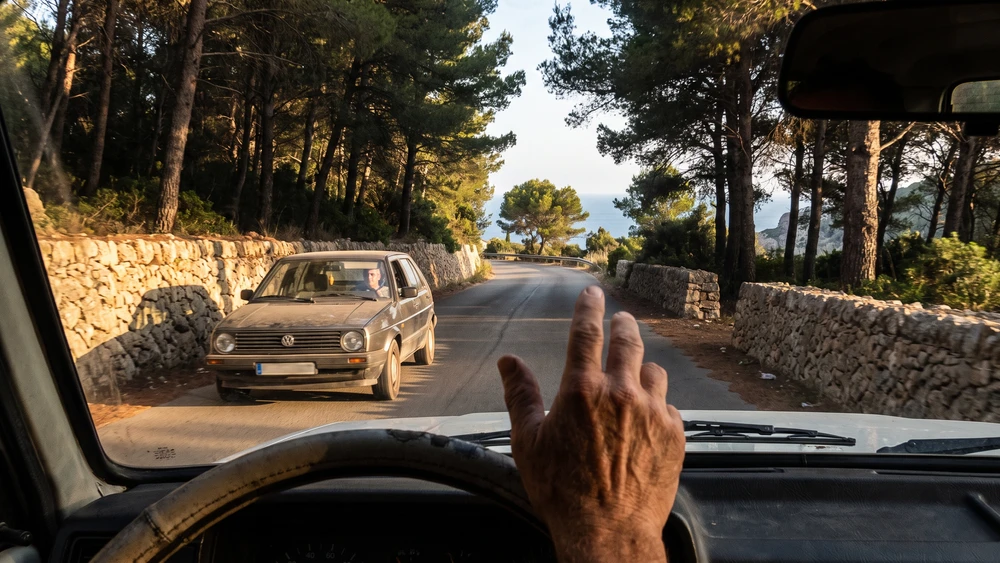 Driver giving the Norfolk Wave on a quiet island road