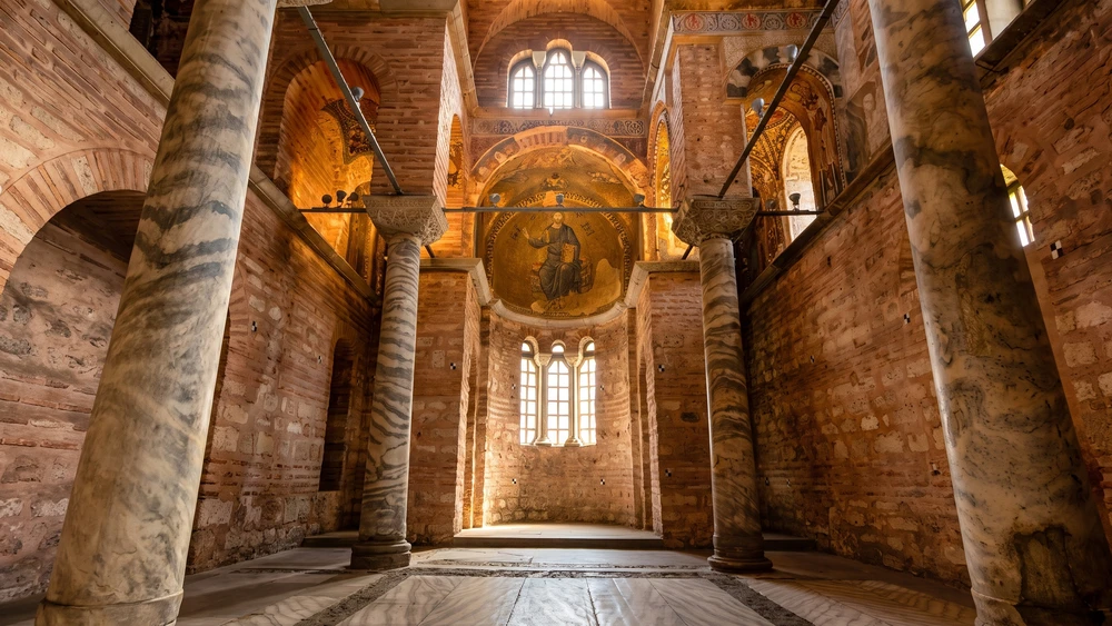 Pammakaristos Church interior in Istanbul showing marble columns, brick arches, and a Byzantine apse mosaic.