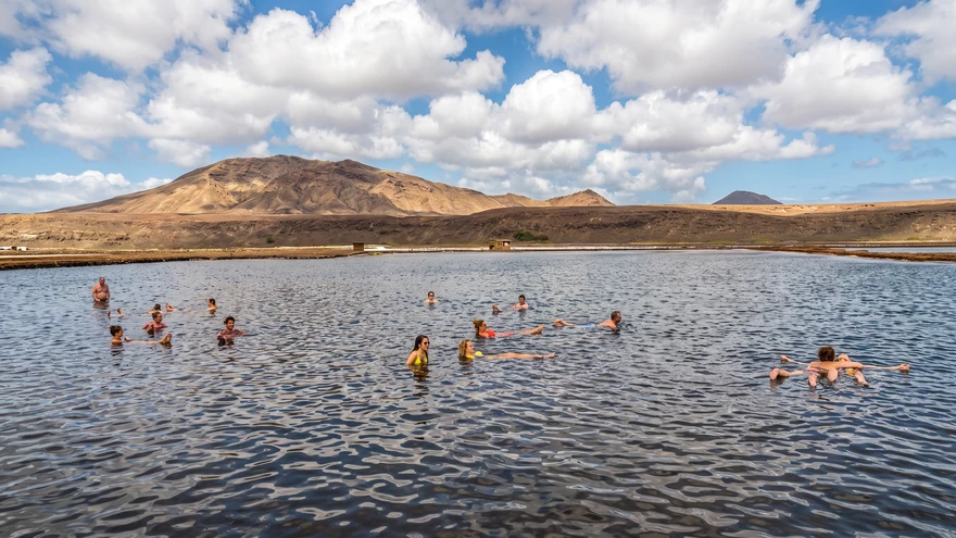 Visitors floating in the hypersaline water of the Pedra de Lume salt lake, Sal