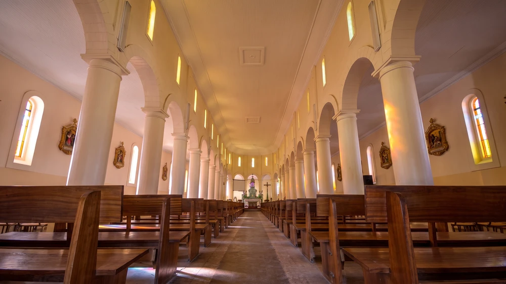 Empty nave and columned arches inside the Immaculate Conception Cathedral at Pella