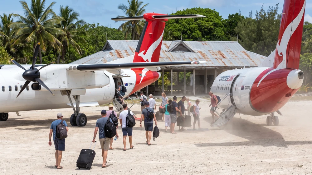 QantasLink turboprop plane boarding passengers at the remote island airport