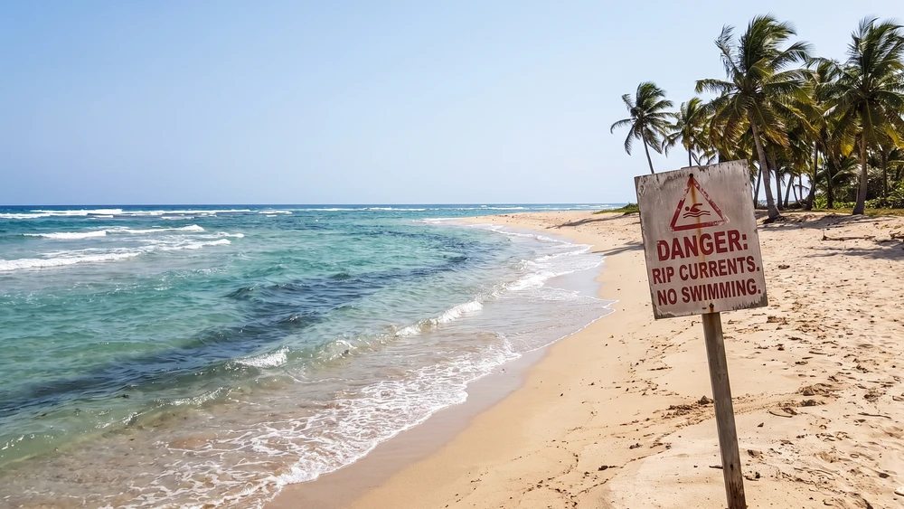 Remote tropical beach channel with no lifeguard and visible rip currents