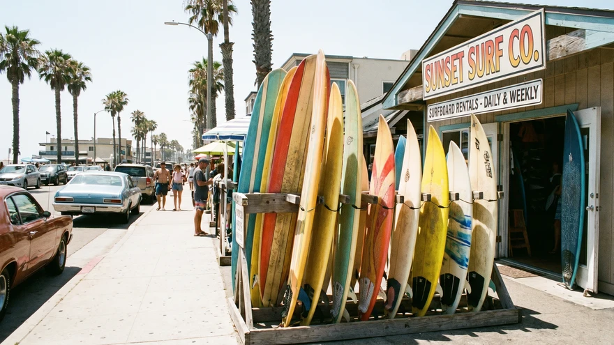 Surfboards for rent lined up outside a surf shop in Santa Maria, Sal