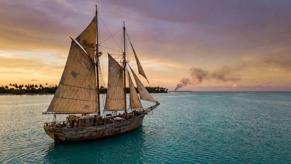 Wooden schooner sailing across a lagoon during the historic 1914 escape from Direction Island