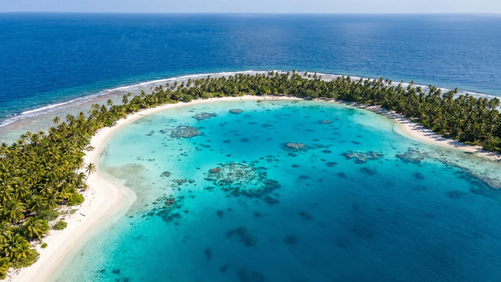 Aerial view of a remote coral atoll and turquoise lagoon in Tokelau